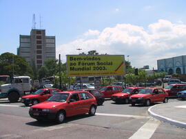 Outdoor Largo da Rodoviária Saída para Avenida Castelo Branco: Bem-vindos ao Fórum Social Mundial 2003. Autor: Ivan de Andrade